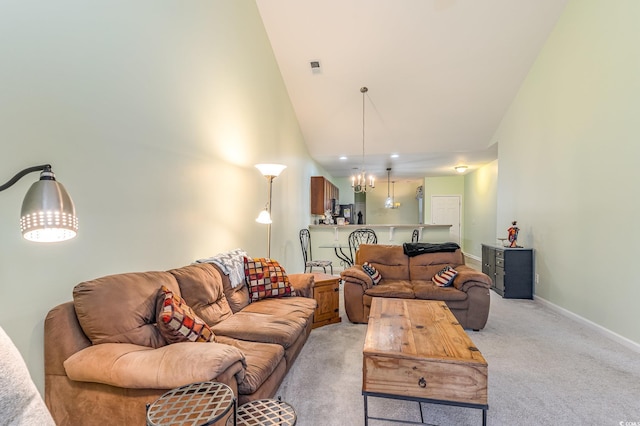 living room with visible vents, a high ceiling, an inviting chandelier, baseboards, and light colored carpet