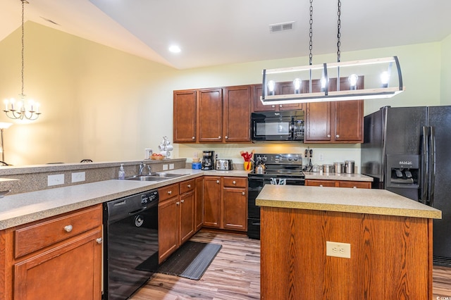 kitchen with visible vents, black appliances, pendant lighting, a sink, and a chandelier