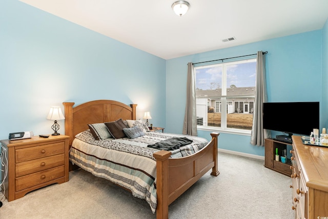 bedroom featuring visible vents, light carpet, and baseboards