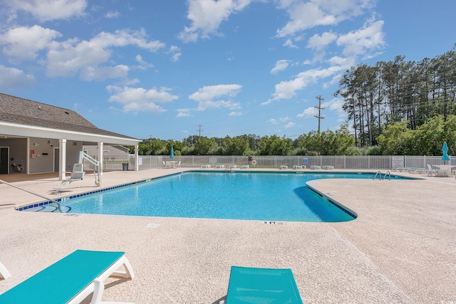 community pool with a patio and fence