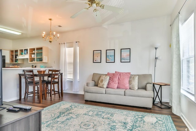 living room with dark hardwood / wood-style floors and ceiling fan with notable chandelier