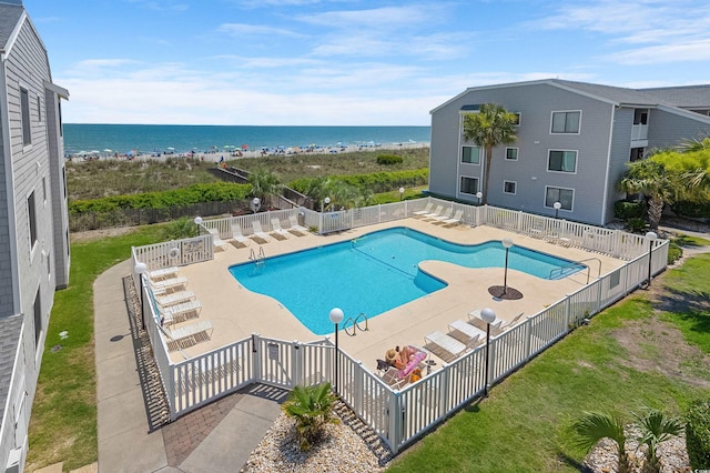 view of pool featuring a water view and a patio