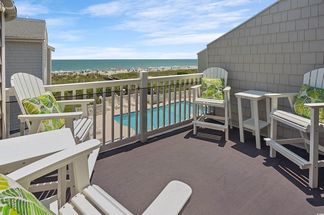 balcony with a water view and a beach view