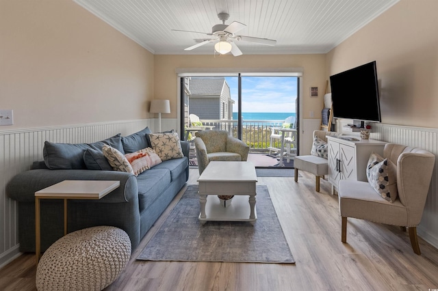 living room featuring hardwood / wood-style flooring, ceiling fan, and ornamental molding