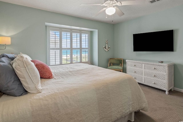 bedroom featuring carpet flooring, a textured ceiling, and ceiling fan