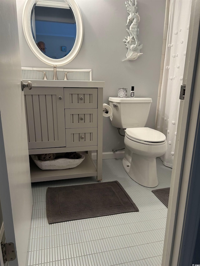 bathroom with vanity, toilet, and tile patterned flooring