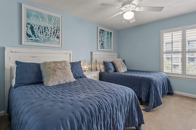 carpeted bedroom featuring a textured ceiling and ceiling fan