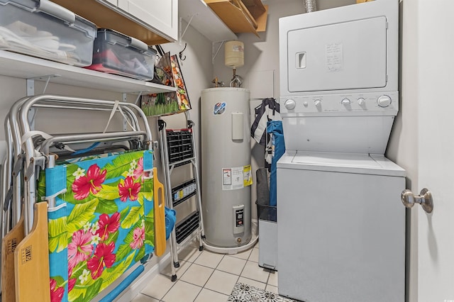 laundry area featuring water heater, stacked washer and dryer, and light tile patterned floors