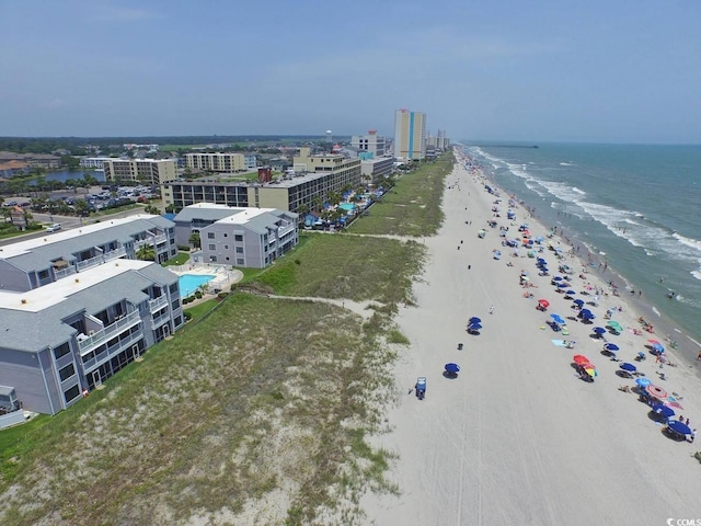 birds eye view of property with a water view and a beach view