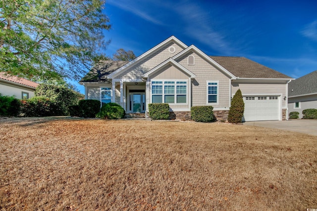 craftsman-style home featuring a front lawn, driveway, and an attached garage