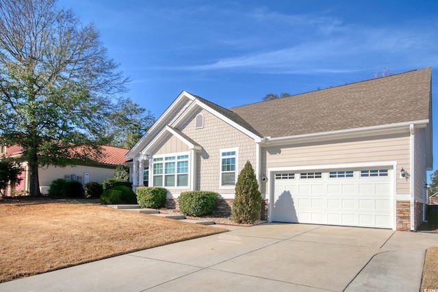 view of front facade with a garage, concrete driveway, roof with shingles, and stone siding