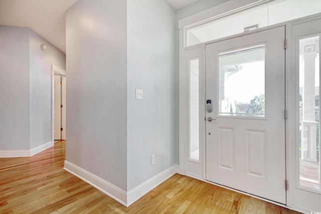 foyer with light wood-style flooring and baseboards