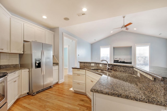 kitchen with tasteful backsplash, stainless steel fridge with ice dispenser, lofted ceiling, light wood-style flooring, and a sink