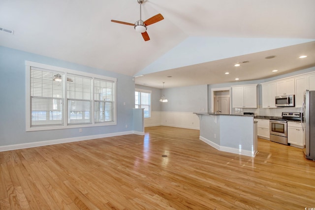 unfurnished living room featuring lofted ceiling, ceiling fan with notable chandelier, visible vents, baseboards, and light wood finished floors