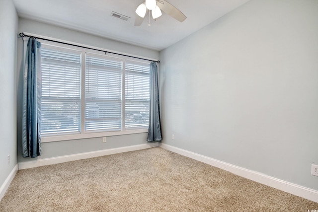 unfurnished room with carpet, visible vents, ceiling fan, and baseboards