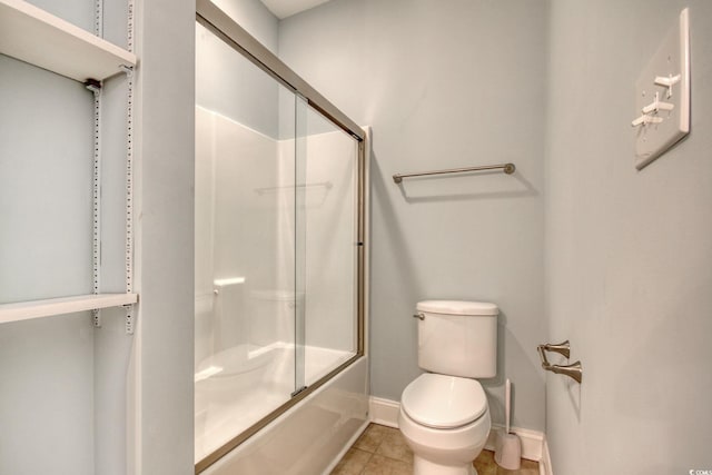 full bathroom with baseboards, combined bath / shower with glass door, toilet, and tile patterned floors