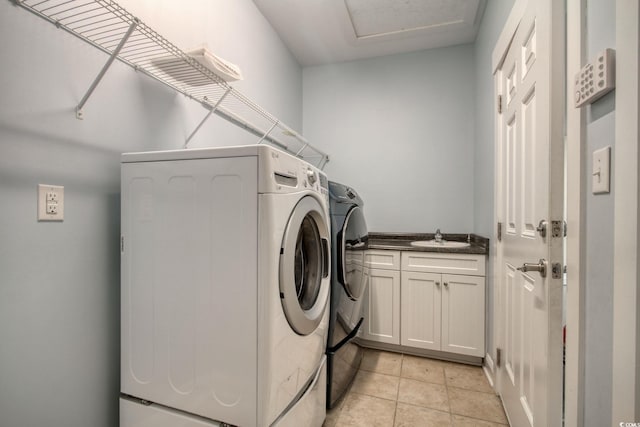 clothes washing area featuring light tile patterned floors, a sink, and separate washer and dryer