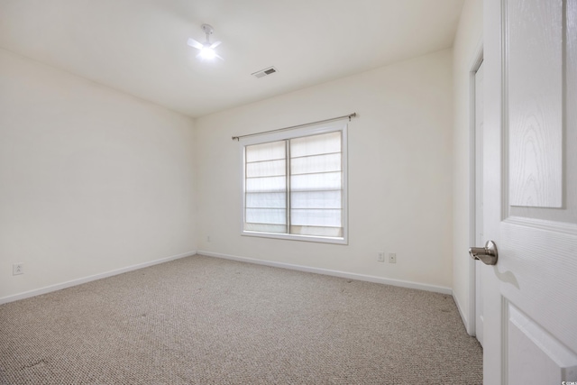 spare room featuring light colored carpet