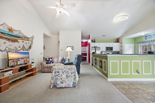 carpeted living room with ceiling fan and lofted ceiling