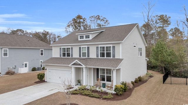 traditional home with a porch, driveway, roof with shingles, an attached garage, and fence