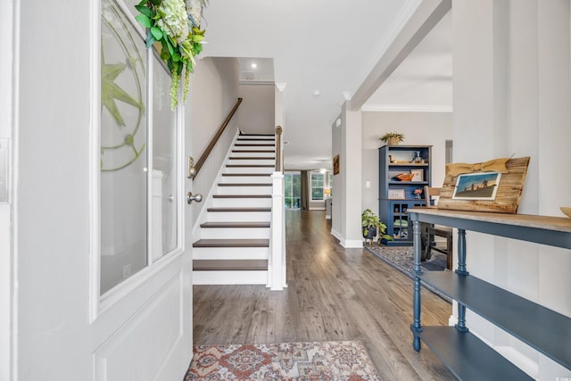 entryway with wood-type flooring and ornamental molding