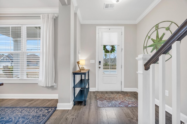 foyer with stairway, crown molding, visible vents, baseboards, and wood finished floors