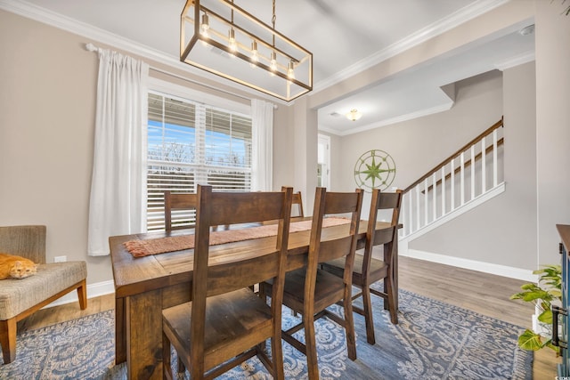 dining area featuring an inviting chandelier, ornamental molding, and wood-type flooring