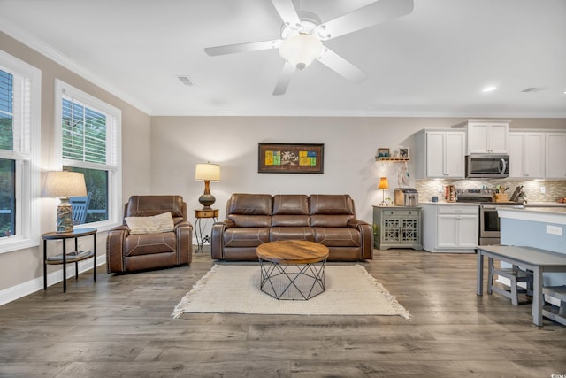 living room featuring crown molding, wood-type flooring, and ceiling fan