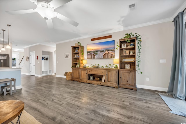 living room featuring crown molding, wood-type flooring, and ceiling fan