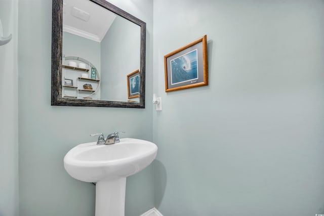 bathroom featuring ornamental molding and a sink