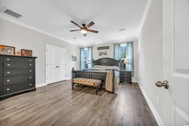 bedroom with crown molding, dark hardwood / wood-style floors, and ceiling fan