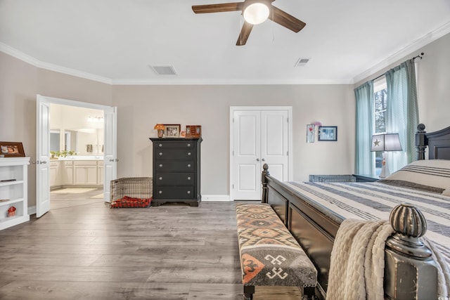 bedroom with crown molding, ceiling fan, ensuite bathroom, wood-type flooring, and a closet