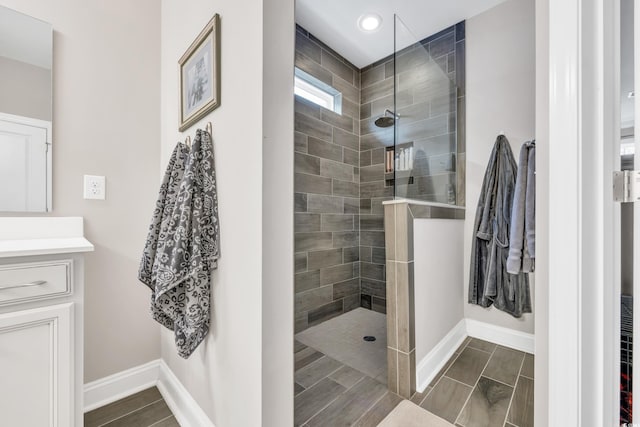 bathroom featuring walk in shower, vanity, recessed lighting, and baseboards
