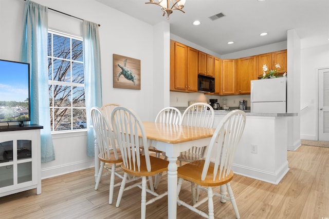 dining room with an inviting chandelier and light hardwood / wood-style floors