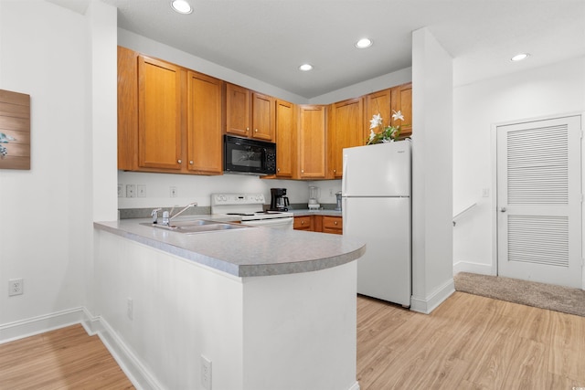 kitchen with kitchen peninsula, sink, white appliances, and light hardwood / wood-style floors