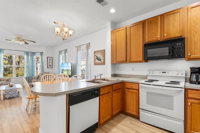 kitchen with kitchen peninsula, sink, white appliances, and light hardwood / wood-style floors