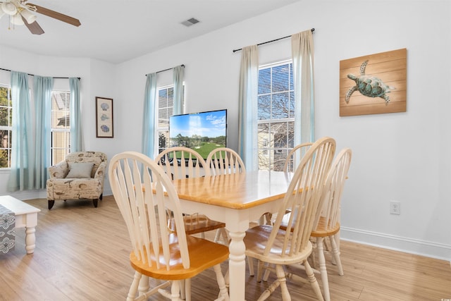 dining room with light wood-type flooring, ceiling fan, and a healthy amount of sunlight