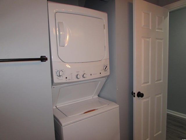 laundry area featuring wood-type flooring and stacked washing maching and dryer