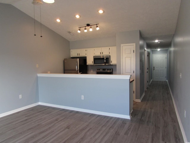 kitchen with white cabinetry, dark hardwood / wood-style flooring, stainless steel appliances, and vaulted ceiling