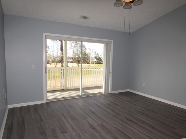 empty room featuring ceiling fan, dark wood-type flooring, and a textured ceiling