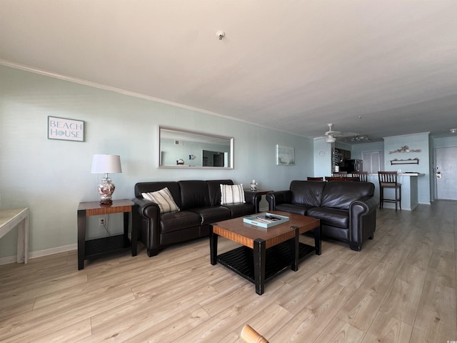 living room featuring ceiling fan, crown molding, and light wood-type flooring