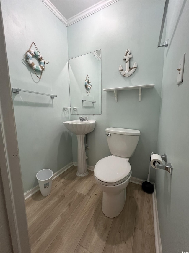 bathroom featuring toilet, crown molding, and hardwood / wood-style floors