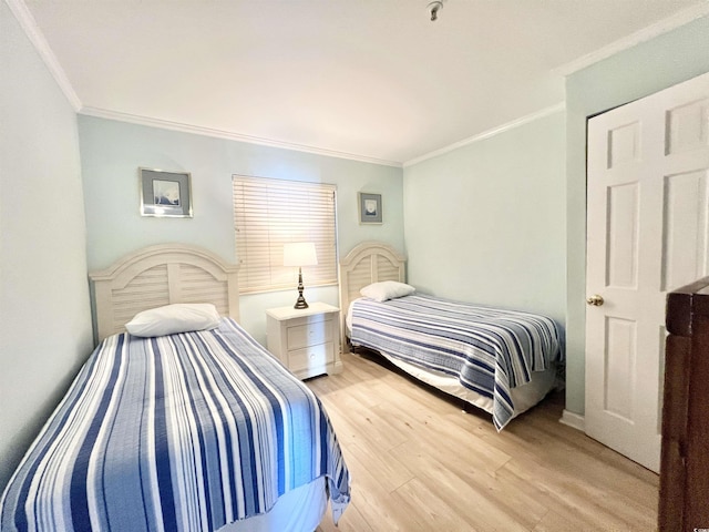 bedroom with light hardwood / wood-style floors and crown molding