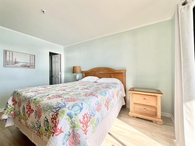 bedroom featuring light hardwood / wood-style floors and crown molding