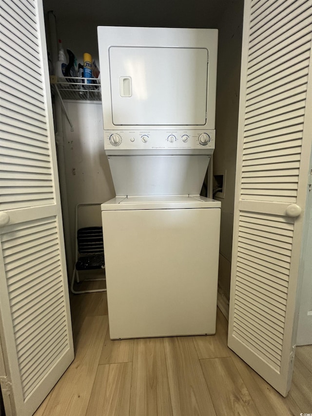 laundry area featuring light hardwood / wood-style flooring and stacked washer and clothes dryer