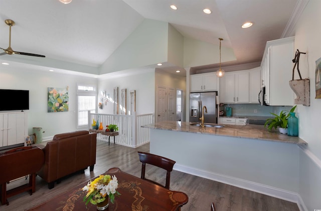 kitchen featuring white cabinetry, decorative backsplash, decorative light fixtures, light stone counters, and sink