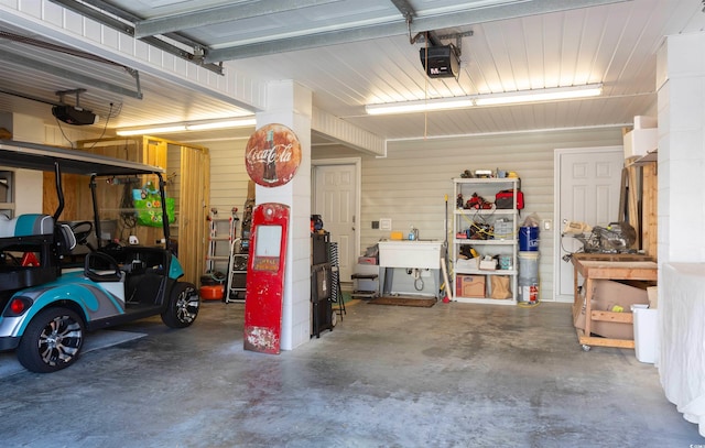 garage featuring a garage door opener and wooden walls