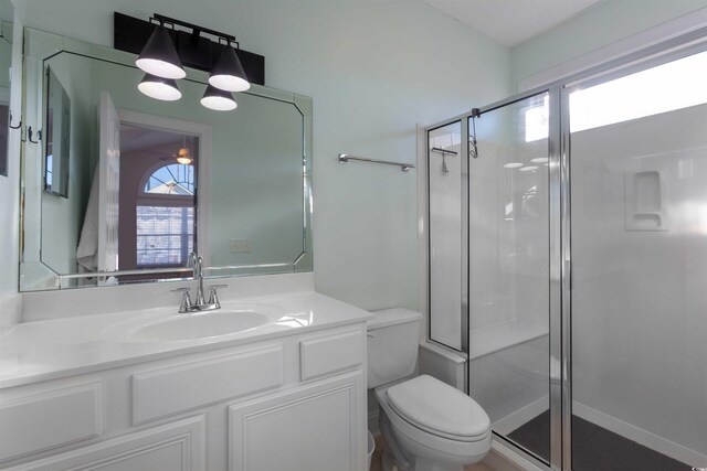 bathroom featuring walk in shower, vanity, and toilet