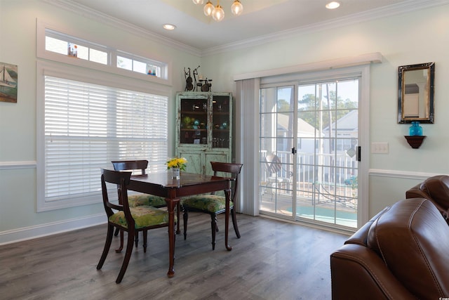 dining space with ornamental molding and dark hardwood / wood-style floors