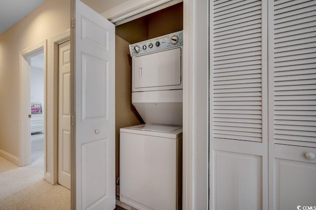 washroom with stacked washer / dryer and light colored carpet